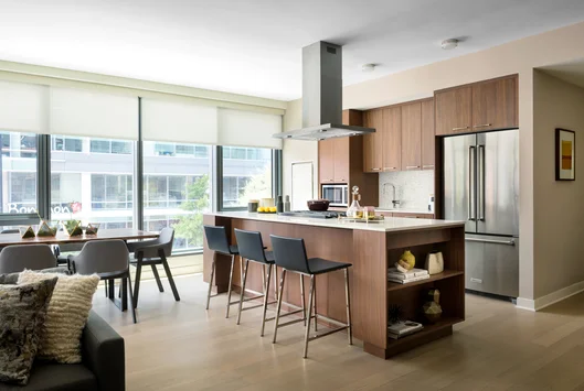 Masterfully appointed kitchens feature custom walnut kitchen cabinetry, polished quartz countertops, and Calacatta marble backsplash.