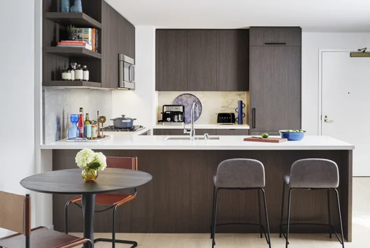 Open kitchens with custom grey-oak cabinetry, Bosch appliances, white Caesarstone counters and a Calacatta Caldia marble slab backsplash.