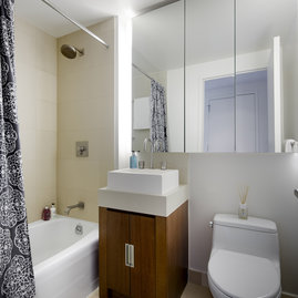 Bathrooms feature golden sandstone tile with arctic white corian vessel sinks.