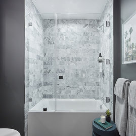 Luxe bathrooms include marble tub surround.