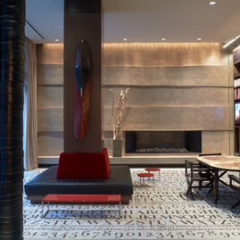 The Assouline Culture Lounge provides a luxurious space to relax next to a dramatic custom-designed graphite cement hearth.