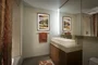 Bathrooms feature golden sandstone tile with arctic white corian vessel sinks.