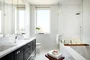 Custom walnut bathroom cabinetry with polished nickel hardware and imported Thassos polished marble countertop and floors, oversized marble showers and double vanities.