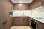 White quartz counters and Calacutta marble backsplash, soft-close wood cabinetry, stainless steel sink and premium stainless steel appliances with integrated wood paneling.