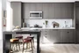 Open kitchens with custom grey-oak cabinetry, Bosch appliances, white Caesarstone counters and a Calacatta Caldia marble slab backsplash.