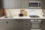 Open kitchens with custom grey-oak cabinetry, Bosch appliances, white Caesarstone counters and a Calacatta Caldia marble slab backsplash.