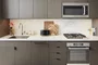Open kitchens with custom grey-oak cabinetry, Bosch appliances, white Caesarstone counters and a Calacatta Caldia marble slab backsplash.