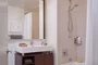 Custom bathrooms with polished natural stone floors, custom walnut vanities, and oversized showers.