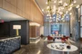 Flooded with natural light, the double-height lobby features an incredible 19-foot Calacatta Cielo stone fireplace and Pietra Grey marble floor.