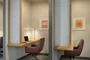 The resident-only co-working lounge includes individual workstations, private offices, and conferencing spaces.