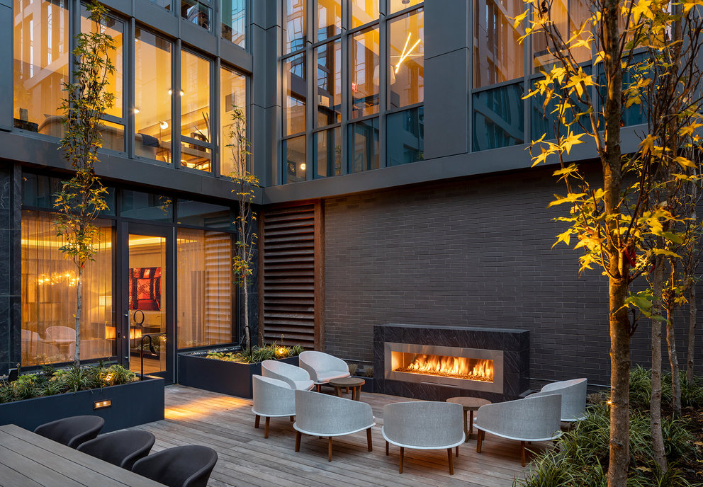 The landscaped courtyard seamlessly integrates the indoors and outdoors with comfortable seating before a fireplace.