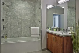 The lavish baths in The Emerson's apartments feature a marble counter and tub surround, walnut vanity with a Toto undermount sink, chrome fixtures and a mirrored medicine cabinet for additional storage.