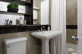 Lavish marble bathrooms with pedestal sinks complement the living spaces in these NYC luxury apartments.