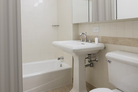 Classic marble bathrooms feature Kohler fixtures and storage-friendly oversized medicine cabinets. 