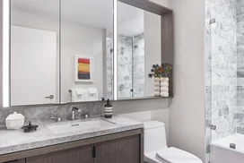 Luxe bathrooms include grey-oak vanities with marble counters, custom medicine cabinets and marble tub surround.