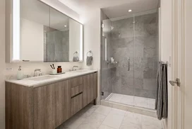 Well-appointed master bathrooms feature vanities with Italian white marble, grey marble walls, and medicine cabinets with integrated lighting and pulls.