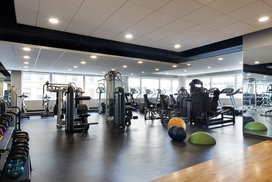 A state-of-the art Health and Fitness Center features cardio and strength equipment and lots of natural light streaming through a wall of windows.