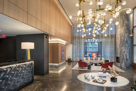 Flooded with natural light, the double-height lobby features an incredible 19-foot Calacatta Cielo stone fireplace and Pietra Grey marble floor.