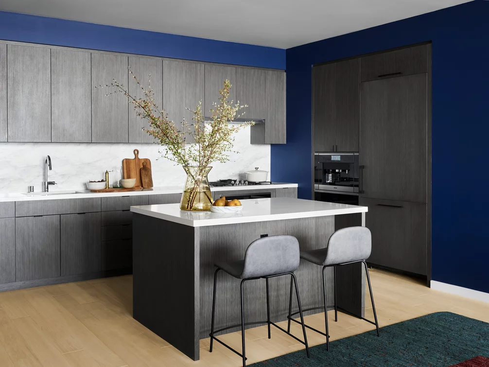 Open kitchens feature a gas cooktop and premium Bosch appliances with integrated paneling, custom grey oak cabinetry, white Caesarstone counters and a marble slab backsplash.