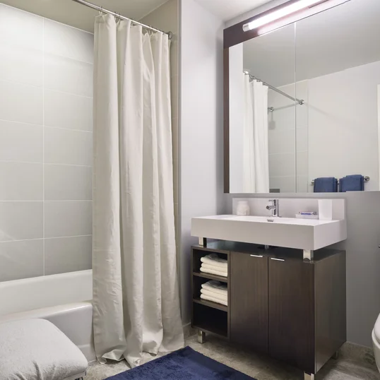 Custom bathrooms with polished natural stone floors, custom walnut vanities, and oversized showers
