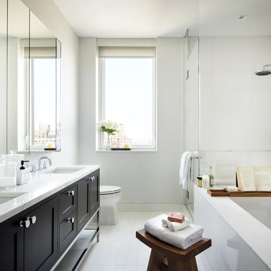Custom walnut bathroom cabinetry with polished nickel hardware and imported Thassos polished marble countertop and floors, oversized marble showers and double vanities.