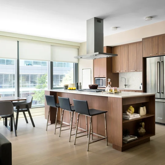 Masterfully appointed kitchens feature custom walnut kitchen cabinetry, polished quartz countertops, and Calacatta marble backsplash.