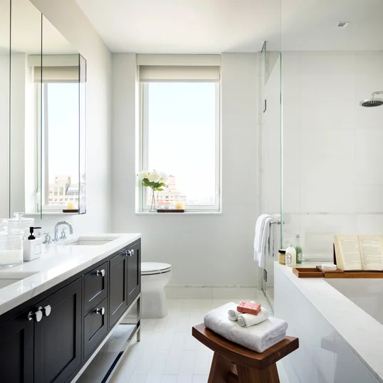 Custom walnut bathroom cabinetry with polished nickel hardware and imported Thassos polished marble countertop and floors, oversized marble showers and double vanities.