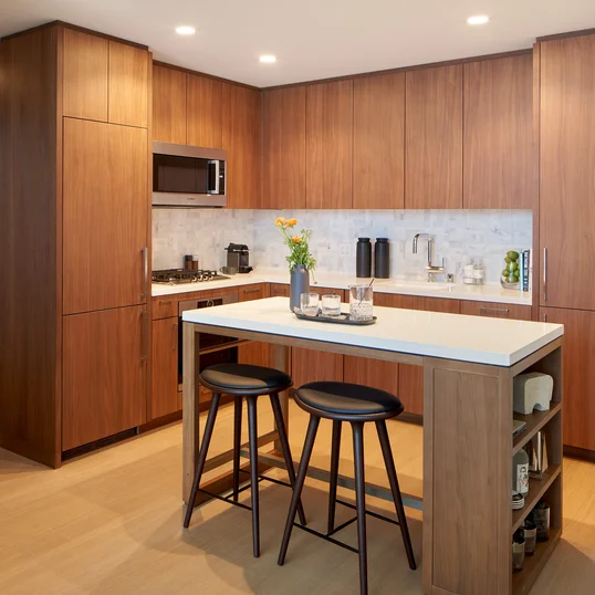 White quartz kitchen counter with a full-height Carrara marble tile backsplash