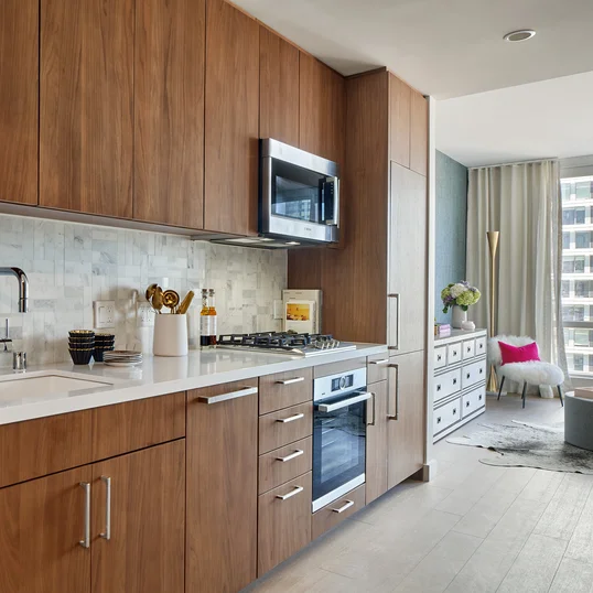 White quartz kitchen counter with a full-height Carrara marble tile backsplash