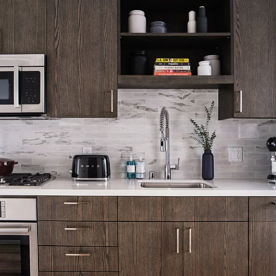 Gourmet kitchens feature gas cooktops and Bosch appliances with quartz counters and a marble backsplash.
