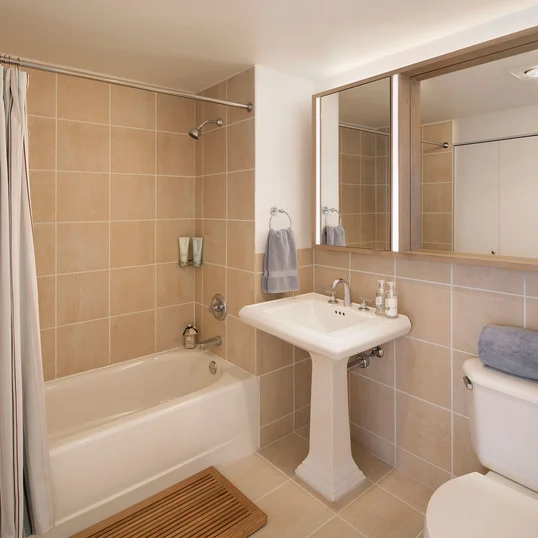 The lavish baths at The Paramount feature a pedestal sink and Italian tile walls and floors.