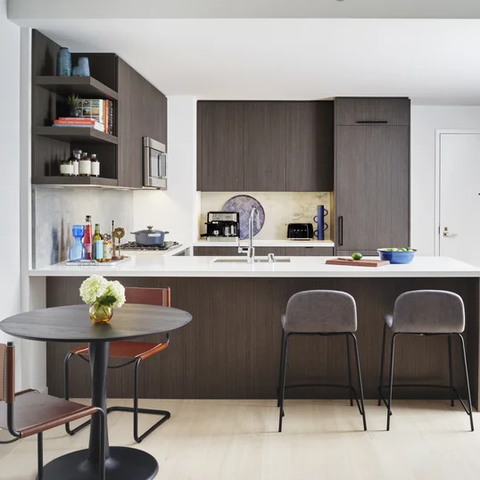 Open kitchens with custom grey-oak cabinetry, Bosch appliances, white Caesarstone counters and a Calacatta Caldia marble slab backsplash.