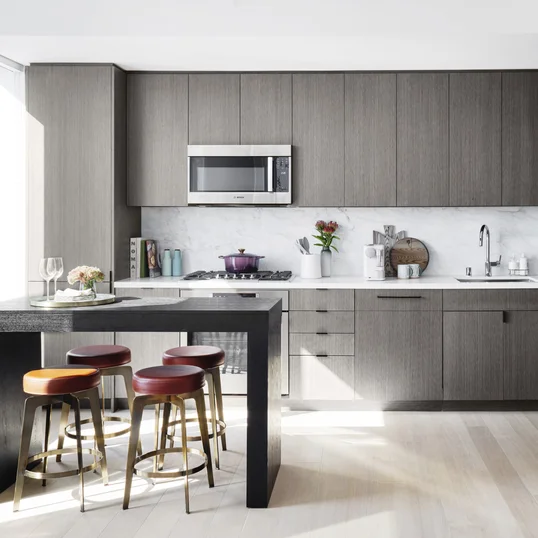 Open kitchens with custom grey-oak cabinetry, Bosch appliances, white Caesarstone counters and a Calacatta Caldia marble slab backsplash.
