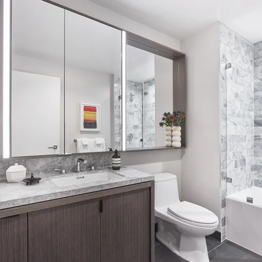 Luxe bathrooms include grey-oak vanities with marble counters, custom medicine cabinets and marble tub surround.