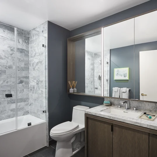Luxe bathrooms include grey-oak vanities with marble counters, custom medicine cabinets and marble tub surround.