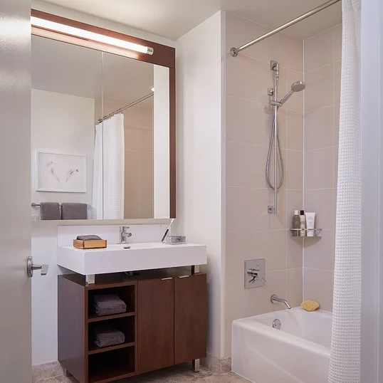 Custom bathrooms with polished natural stone floors, custom walnut vanities, and oversized showers.