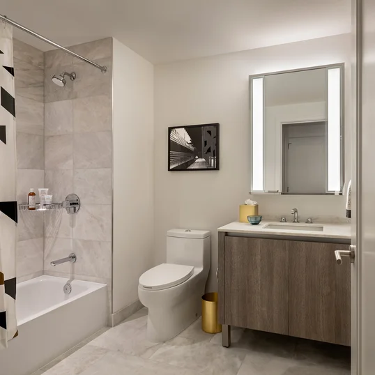 Well-appointed master bathrooms feature vanities with Italian white marble, grey marble walls, and medicine cabinets with integrated lighting and pulls.