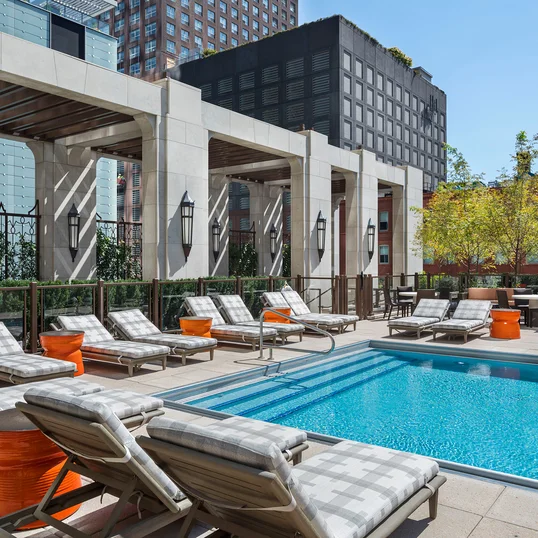 Terrace pool with lounge areas, reservable outdoor kitchens and cabanas, and fire pits.