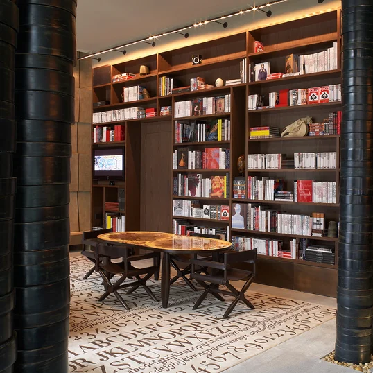 The Assouline Culture Lounge provides a luxurious space to relax next to a dramatic custom-designed graphite cement hearth.