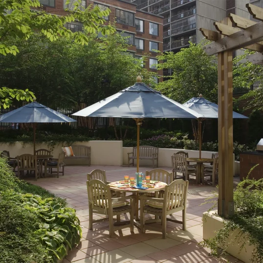 The meticulously landscaped garden patio includes outdoor dining space with barbeques for residents.
