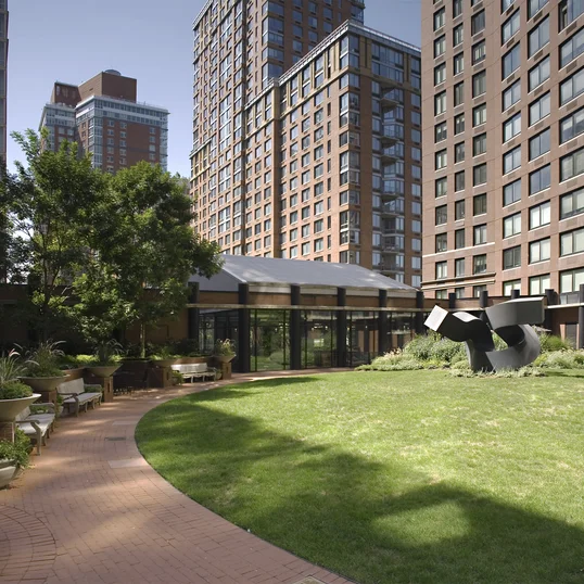 Residents relax in a lushly landscaped private garden anchored by artist Clement Meadmore's monumental steel sculpture.