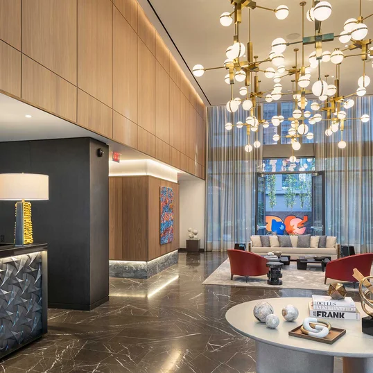 Flooded with natural light, the double-height lobby features an incredible 19-foot Calacatta Cielo stone fireplace and Pietra Grey marble floor.