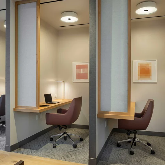 The resident-only co-working lounge includes individual workstations, private offices, and conferencing spaces.