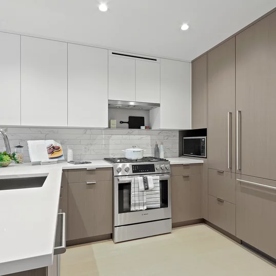 Open kitchen with custom cabinetry, premium stainless steel, gas appliances and flexible dining space